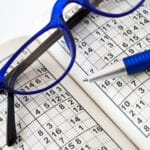Sudoku Heft mit Brille und Kugelschreiber um Gedächtnistricks zu lernen