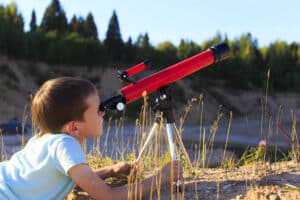 Ein Kind schaut durch ein Teleskop Fernrohr
